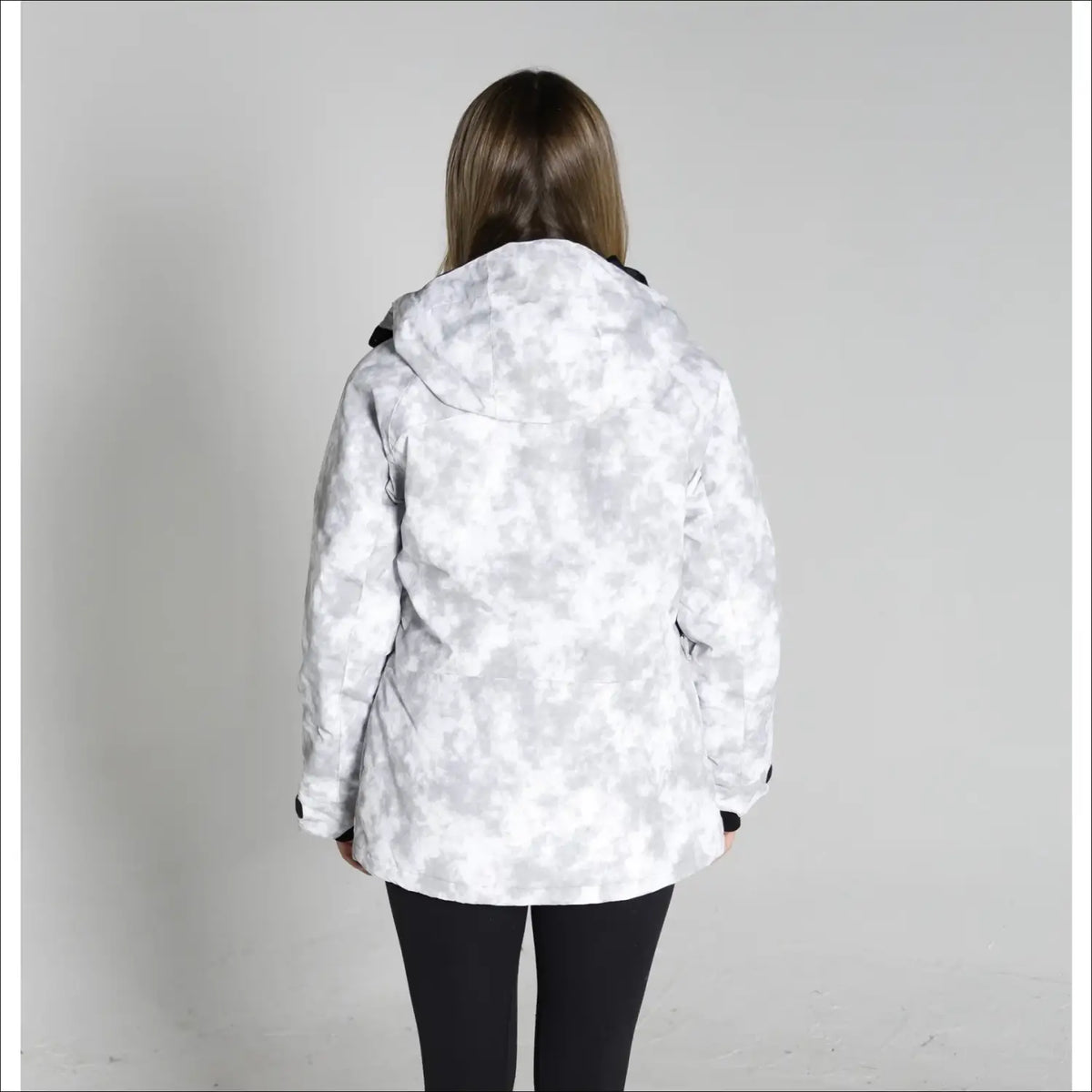 Woman wearing a white and gray camouflage Snow Country Women’s ski coat for winter snowboarding