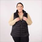 Woman wearing a black plus size synthetic down vest in outdoor setting