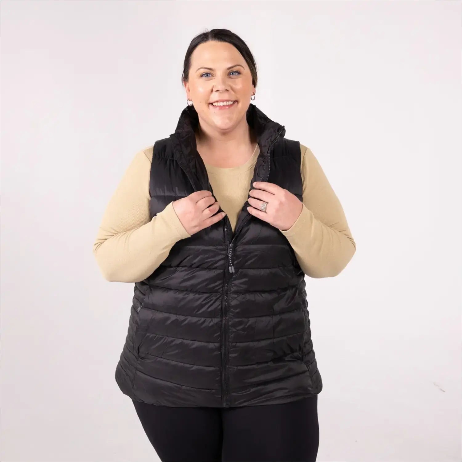 Woman wearing a black plus size synthetic down vest in outdoor setting