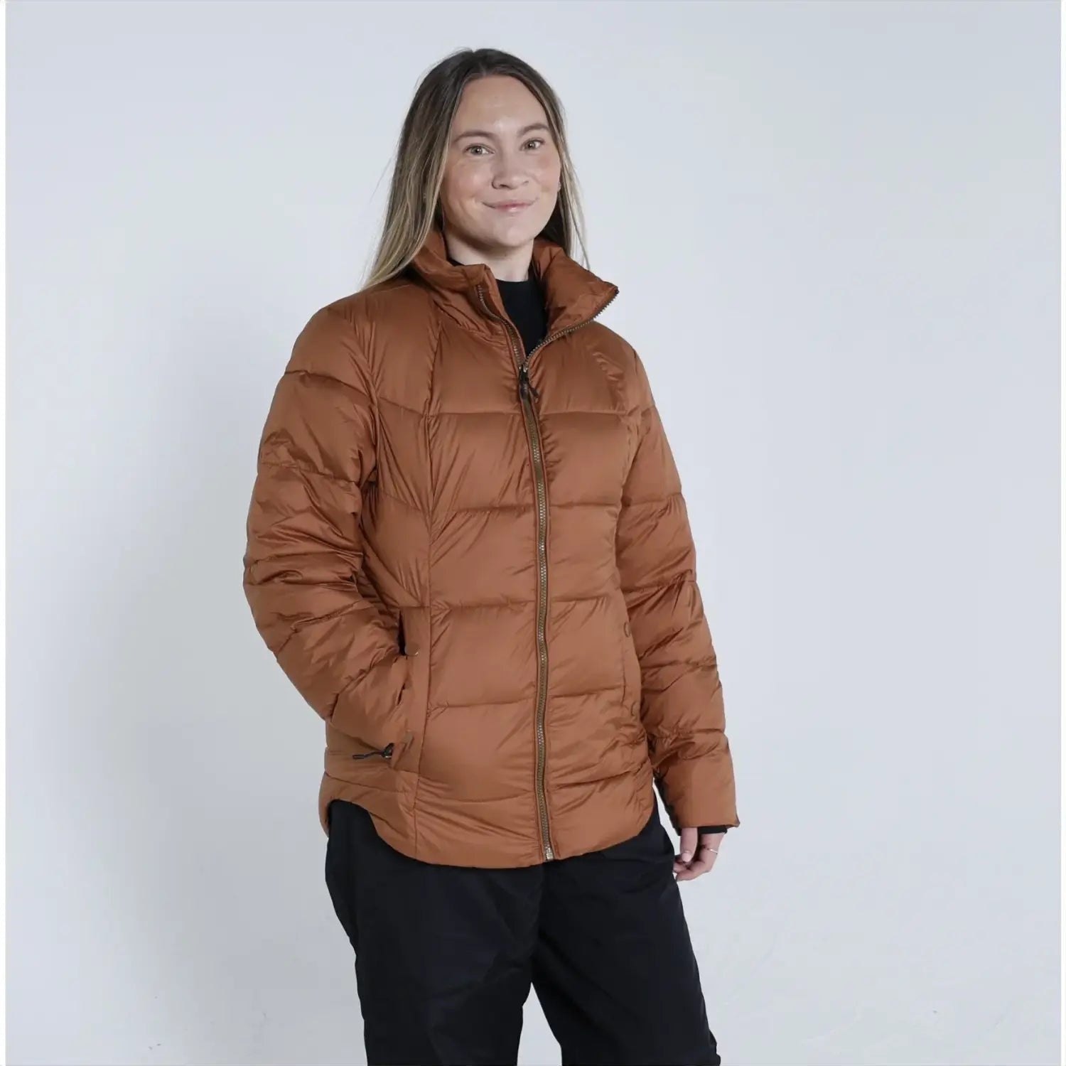 Woman wearing a brown puffer jacket from Snow Country Outerwear Lexington collection