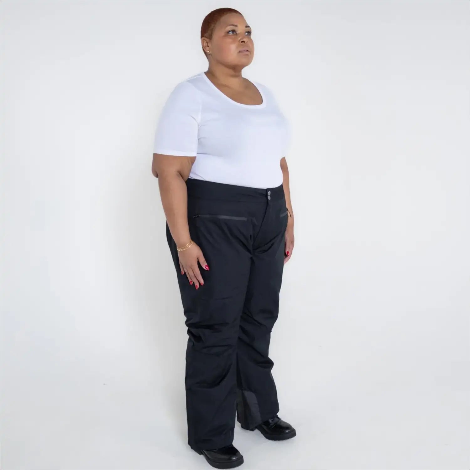 Woman in black ski pants and white t-shirt wearing Women’s Plus Size Winter Ski Pants