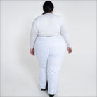 Woman in white winter skiing outfit wearing insulated snow ski pants outdoor scene