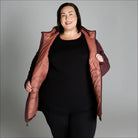 Woman wearing an open quilted packable down hooded coat ideal for snow country outdoor wear