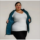 Woman in open teal puffer jacket showcasing women’s 1X-6X plus size packable down coat