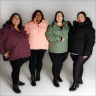 Four women wearing vibrant Snow Country Outerwear plus size winter snow ski coats