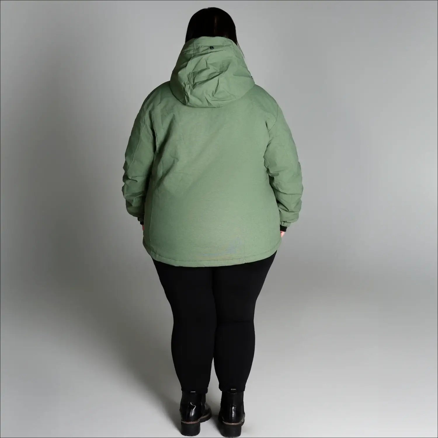 Woman wearing a light green hooded snow ski winter coat from Snow Country Outerwear