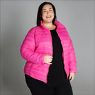 Woman wearing a bright pink plus size winter down alternative 3-in-1 coat jacket in snow country