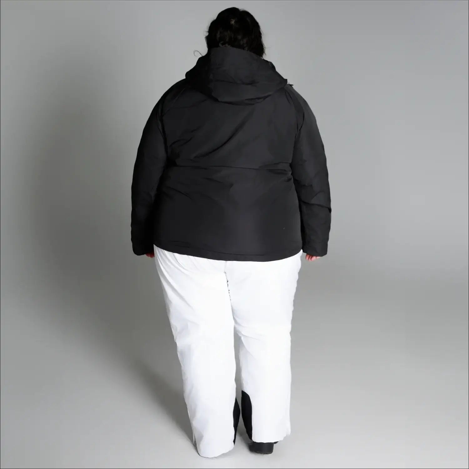 Plus size winter coat with black hooded jacket and white snow pants for snowy outdoor wear