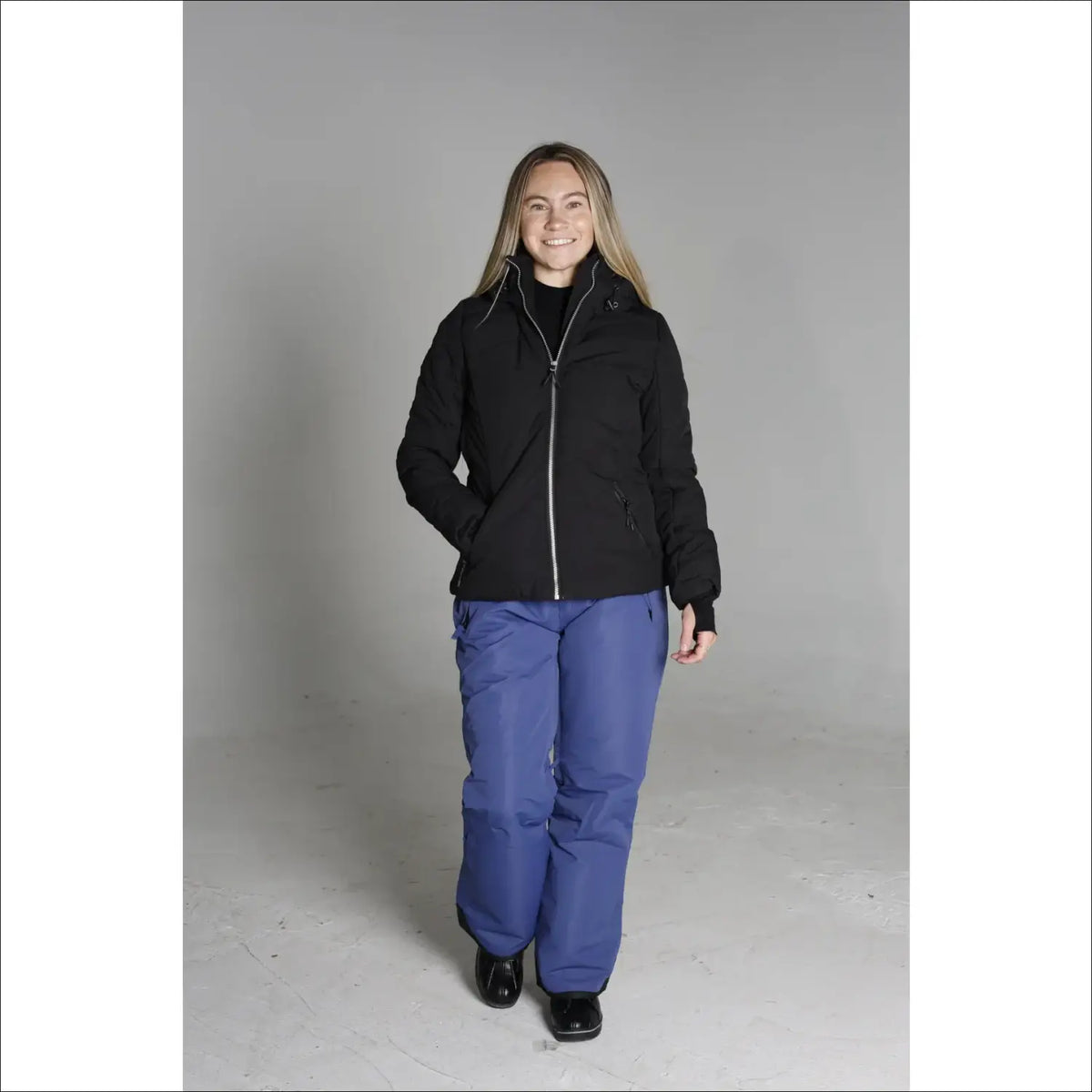 Woman wearing black jacket and blue snow pants in Snow Country Outerwear Vail Ski Jacket