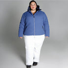 Woman in blue puffer jacket and white pants wearing Snow Country Outerwear Womens Plus Size Vail Ski Coat