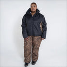 Woman in black jacket and leopard print pants wearing Snow Country insulated ski pants