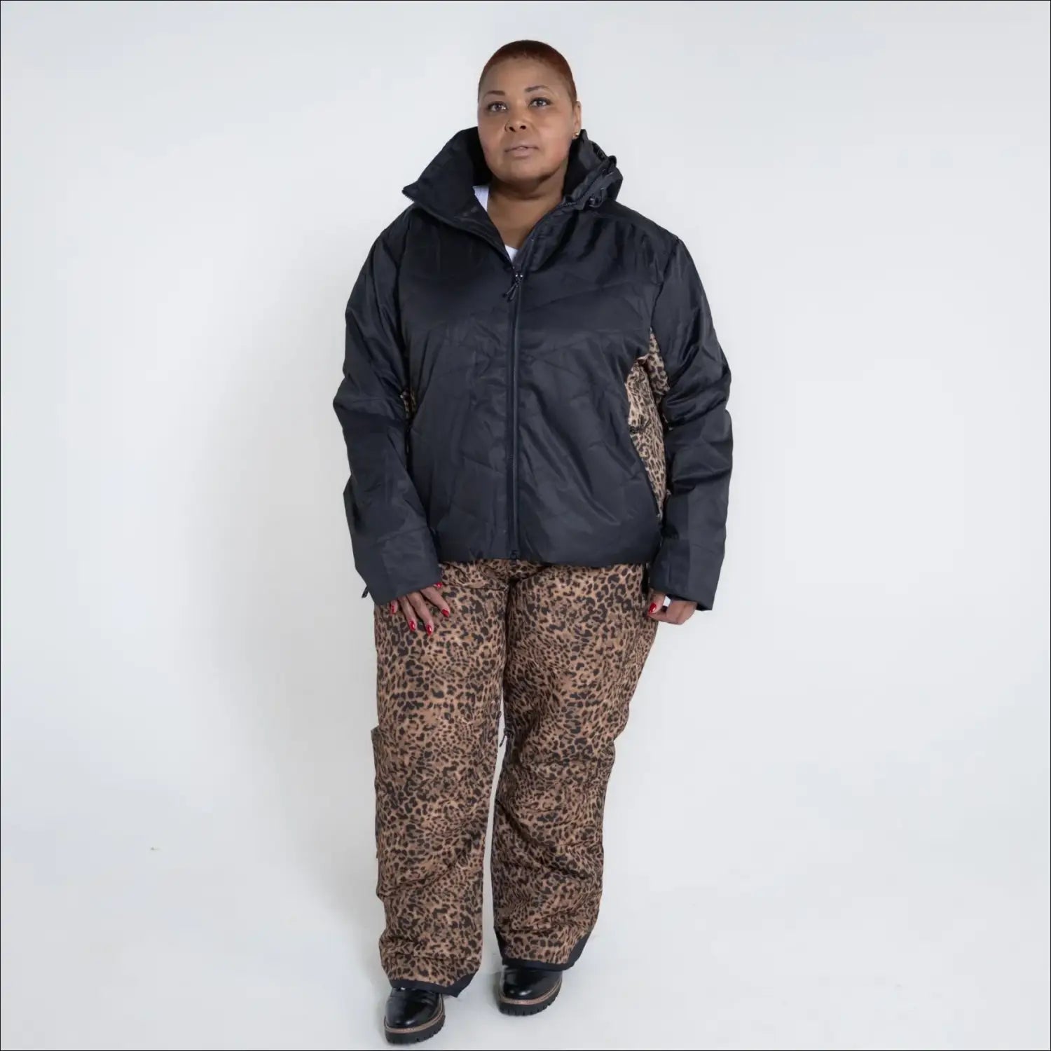 Woman in black jacket and leopard print pants wearing Snow Country insulated ski pants