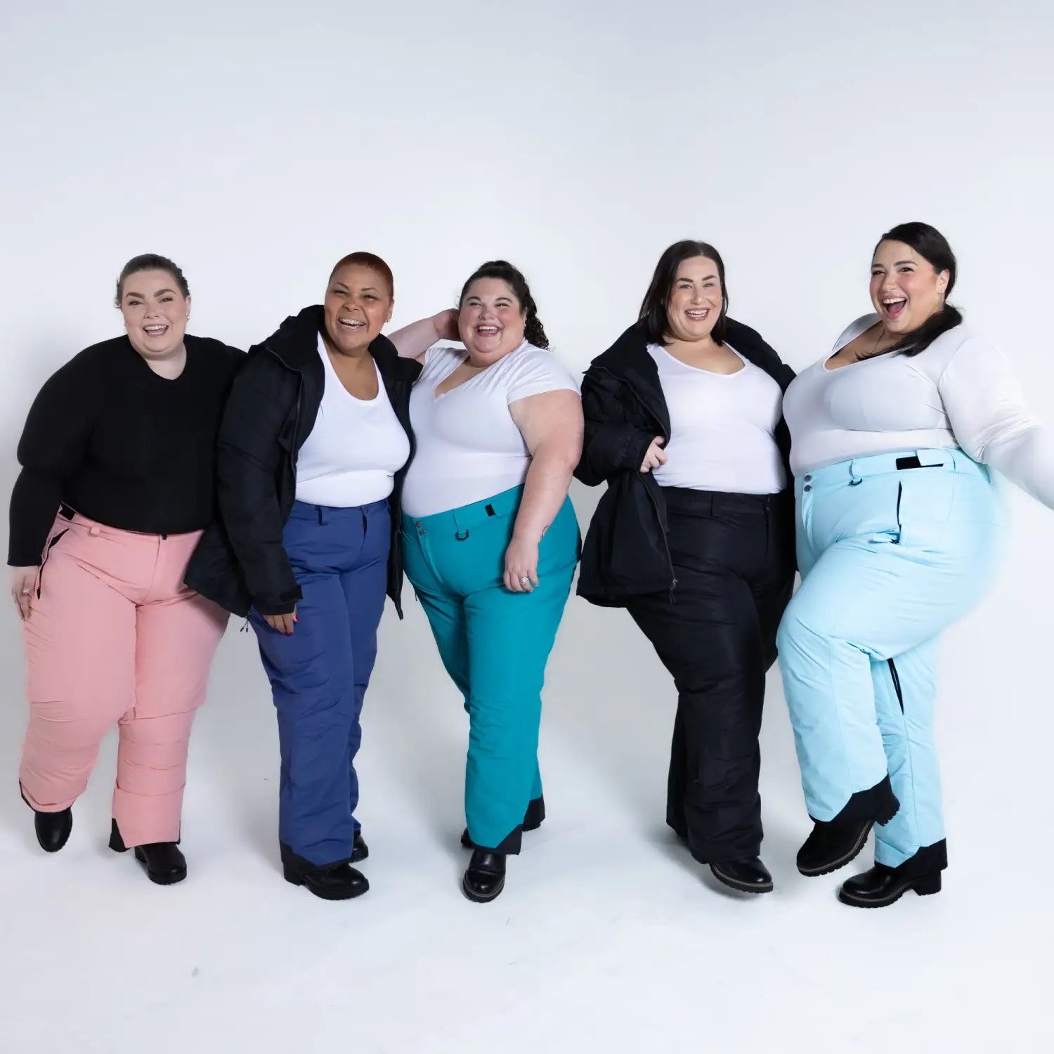 Plus-size women wearing colorful Snow Country insulated ski pants for winter outdoor activities
