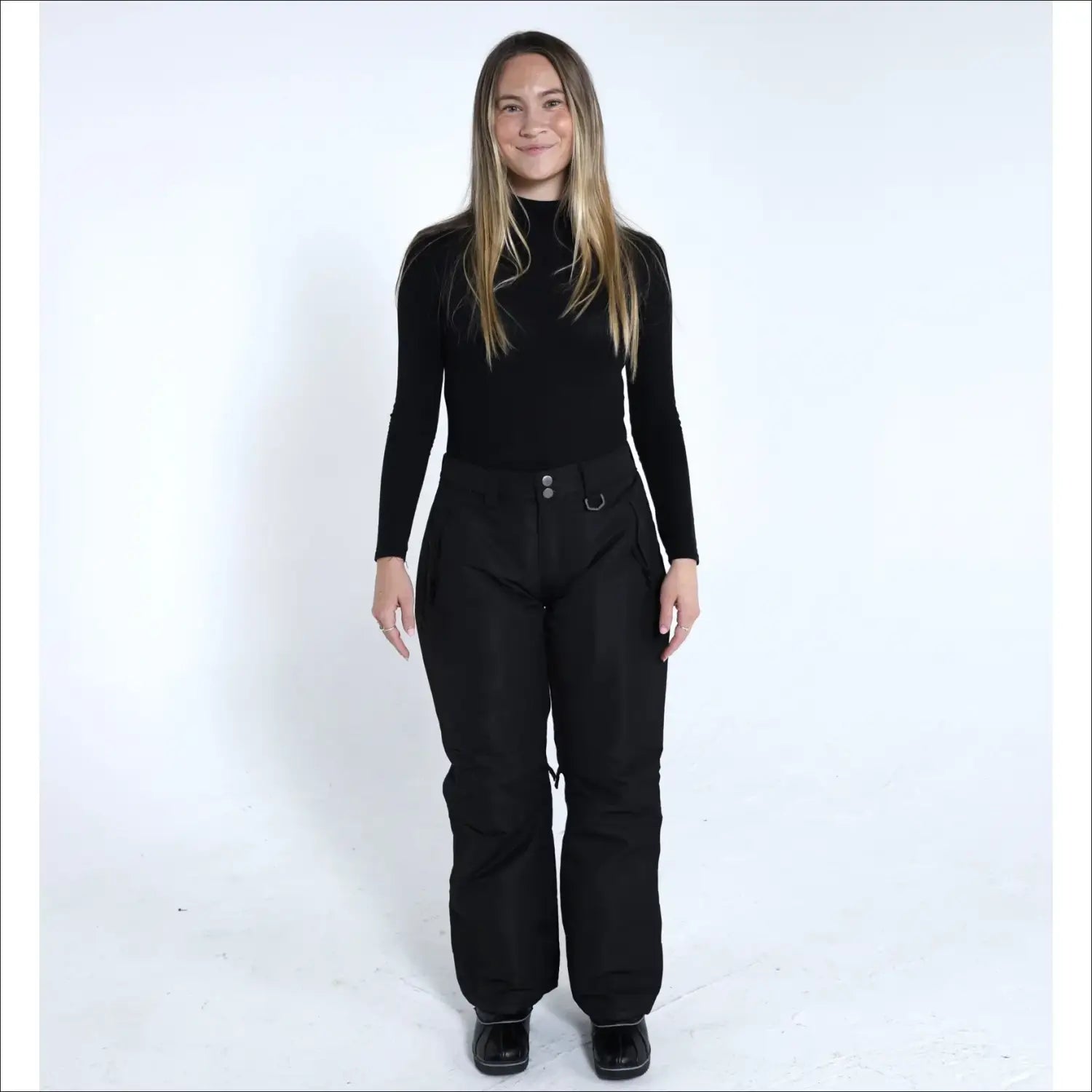 Woman wearing black ski pants and turtleneck from Snow Country Outerwear Ski Collection