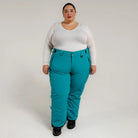 Woman wearing teal Snow Country insulated ski pants for plus size winter outdoor activity