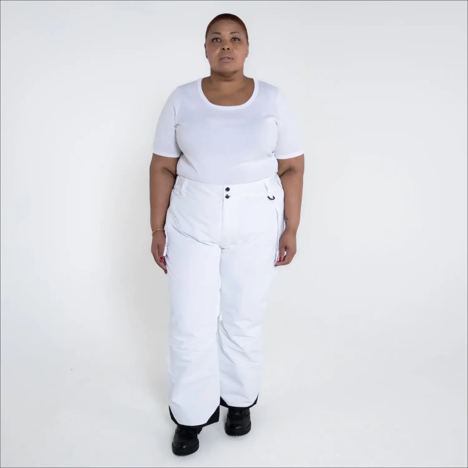 Woman wearing white insulated ski pants in Snow Country Outerwear Plus Size collection