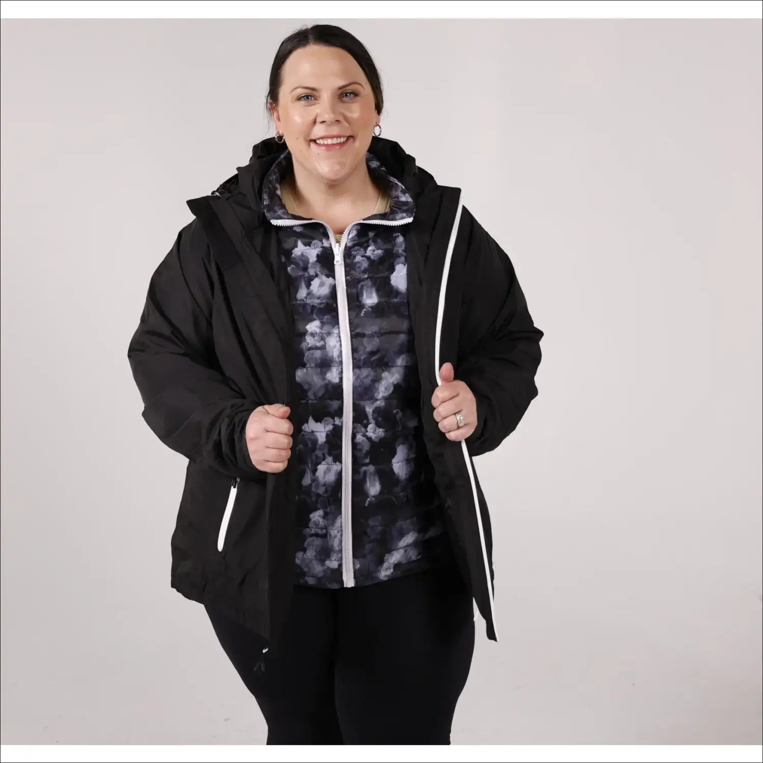 Woman wearing a black jacket with a patterned vest in winter outerwear suitable for plus size women