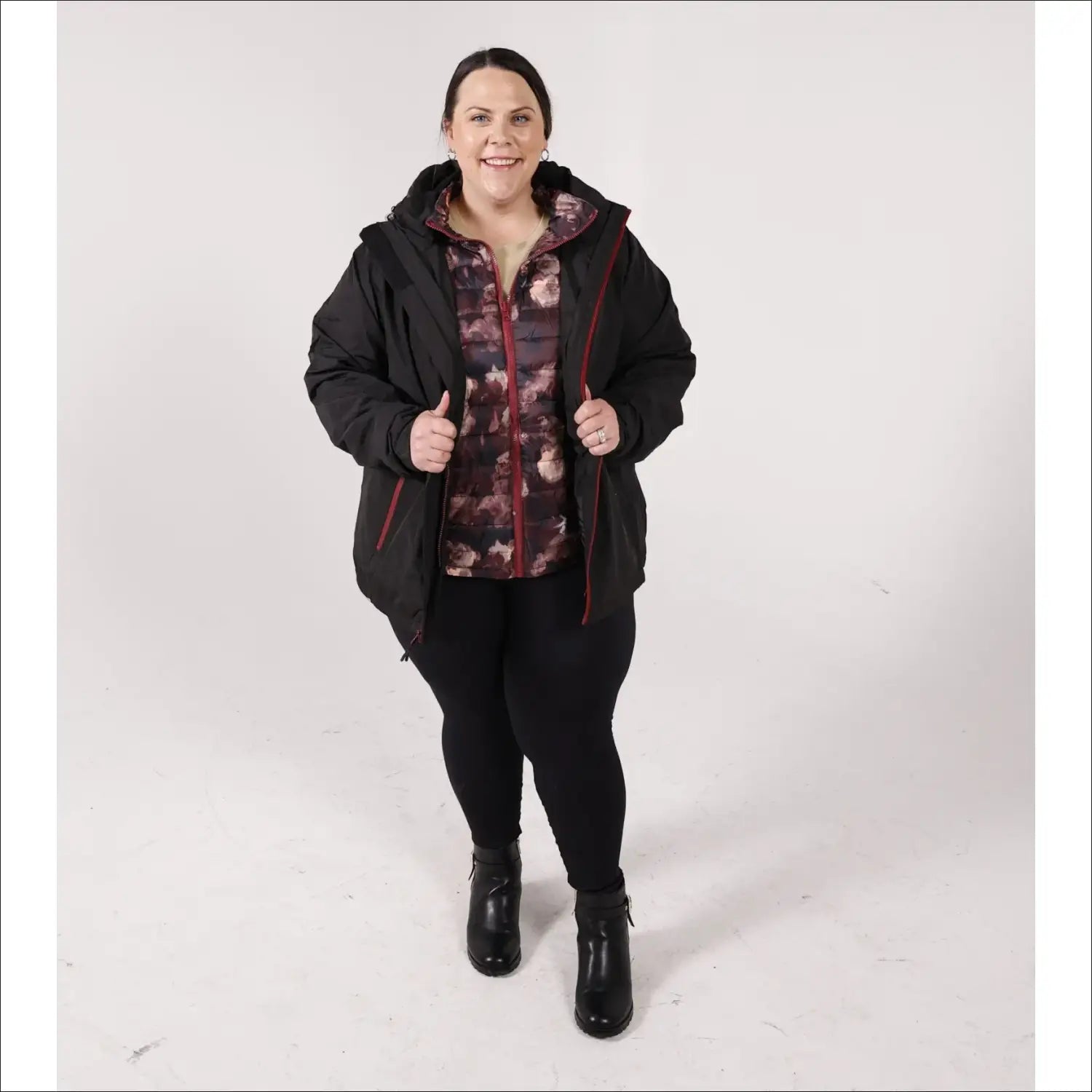 Woman wearing a black hooded winter down alternative 3-in-1 coat jacket outdoors