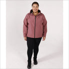 Woman wearing a mauve hooded micro fleece soft shell jacket and black leggings outdoor outerwear