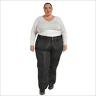 Woman wearing black Snow Country insulated plus size ski pants in a snowy mountain setting