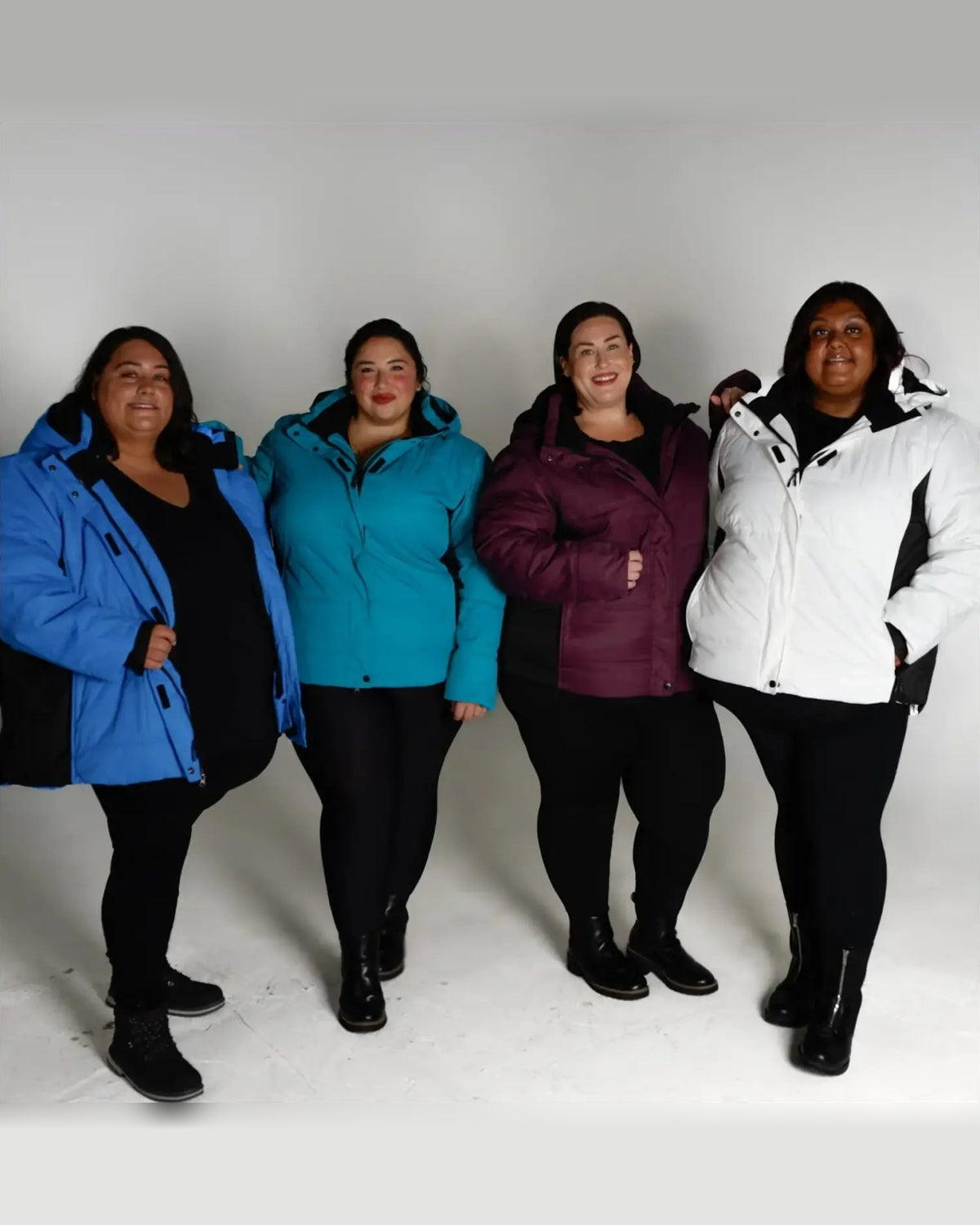 Four plus-size women wearing colorful Snow Country Outerwear Aspen Ski Jackets