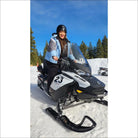 White and black Ski-Doo snowmobile next to Snow Country Outerwear women’s ski jacket