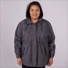 Gray plus size rain jacket on model, front image with hood up