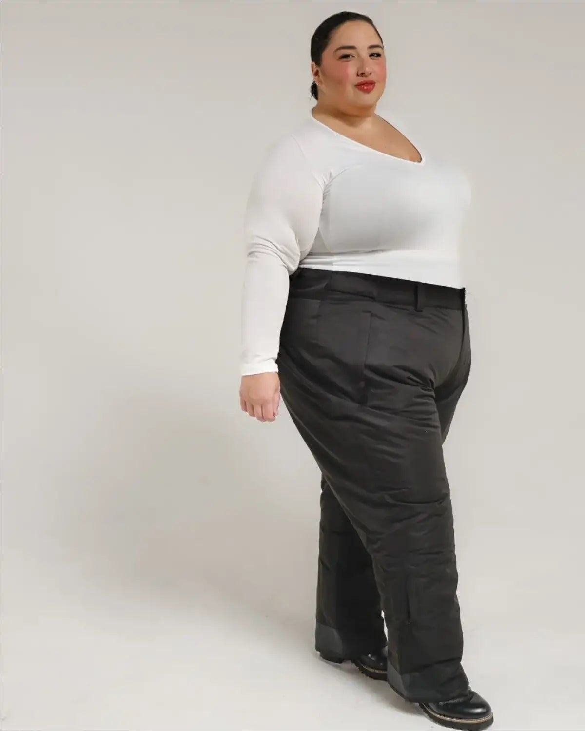 Woman wearing a white top and black pants showcasing Snow Country Plus Size Insulated Ski Pants