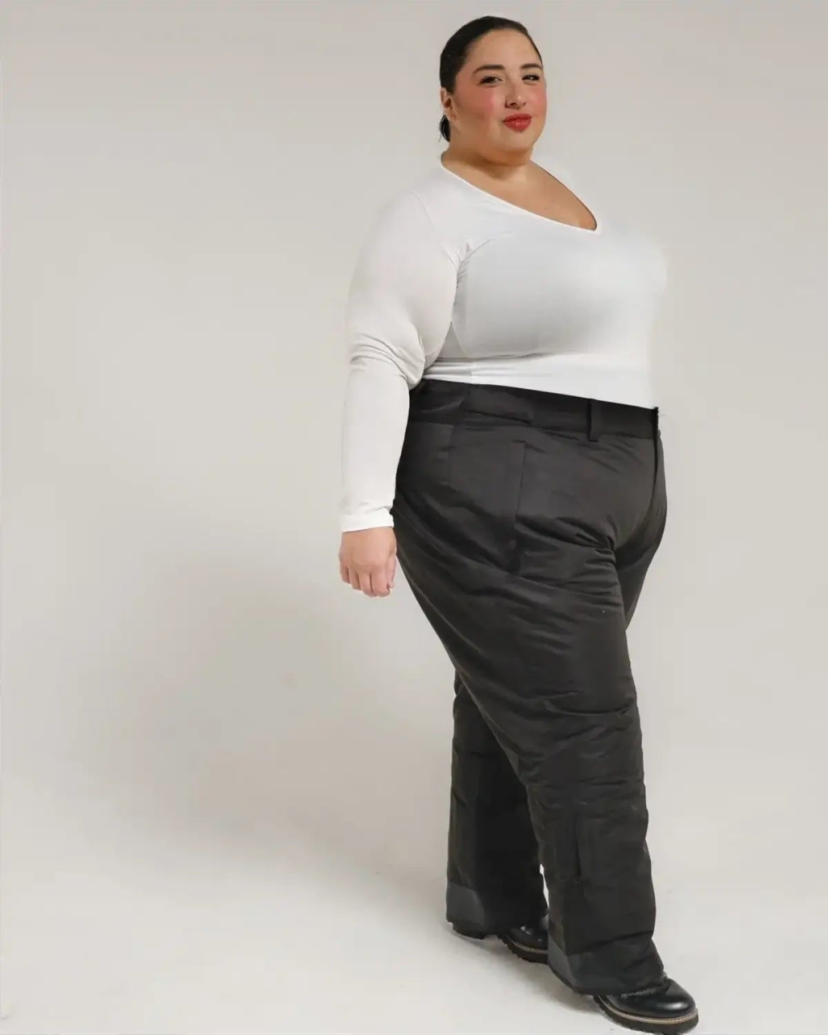 Woman wearing a white top and black pants showcasing Snow Country Plus Size Insulated Ski Pants