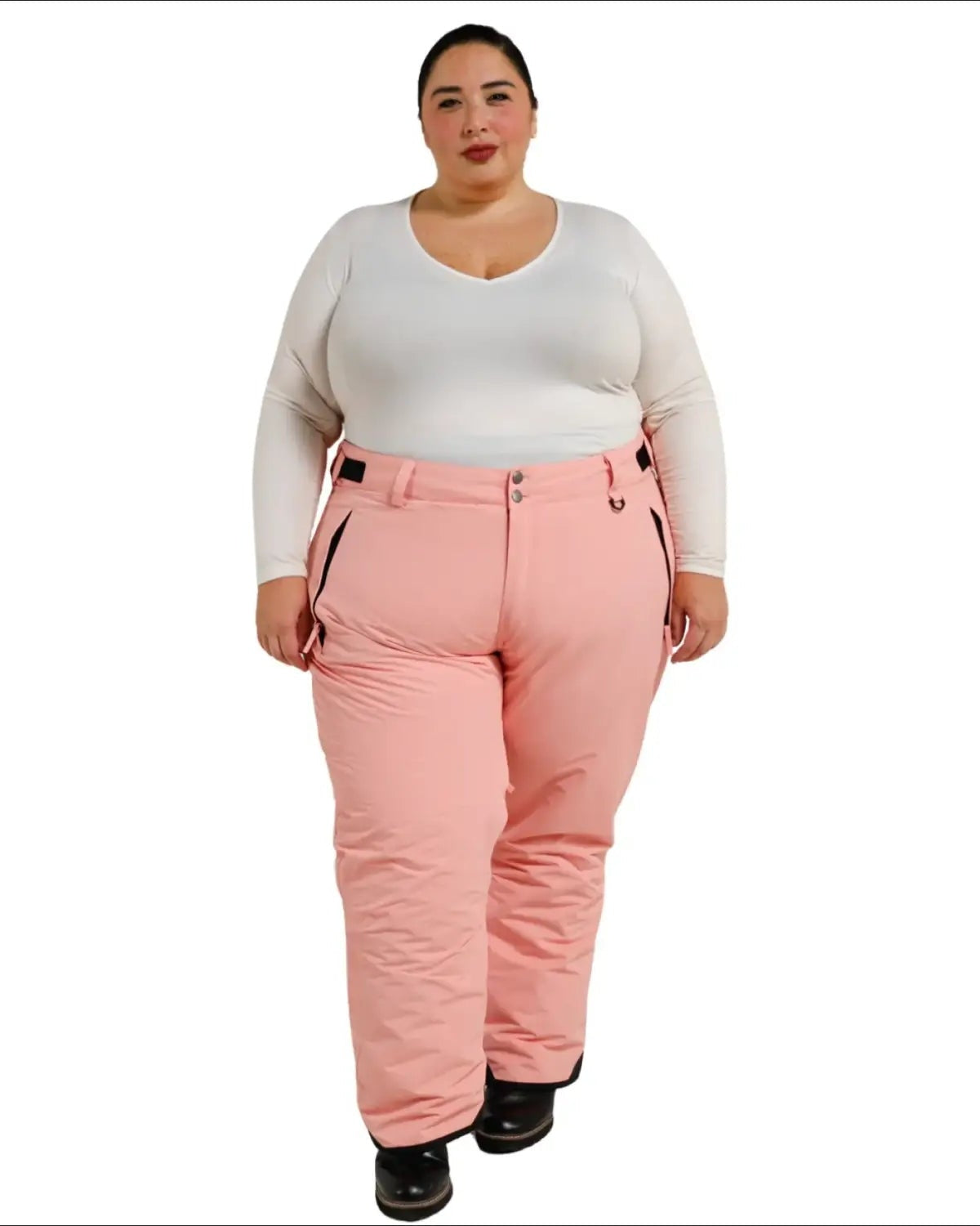 Woman wearing pink snow pants and white long-sleeved shirt for Snow Country Outerwear ski gear