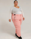 Woman wearing pink Snow Country insulated ski pants in a winter outdoor setting