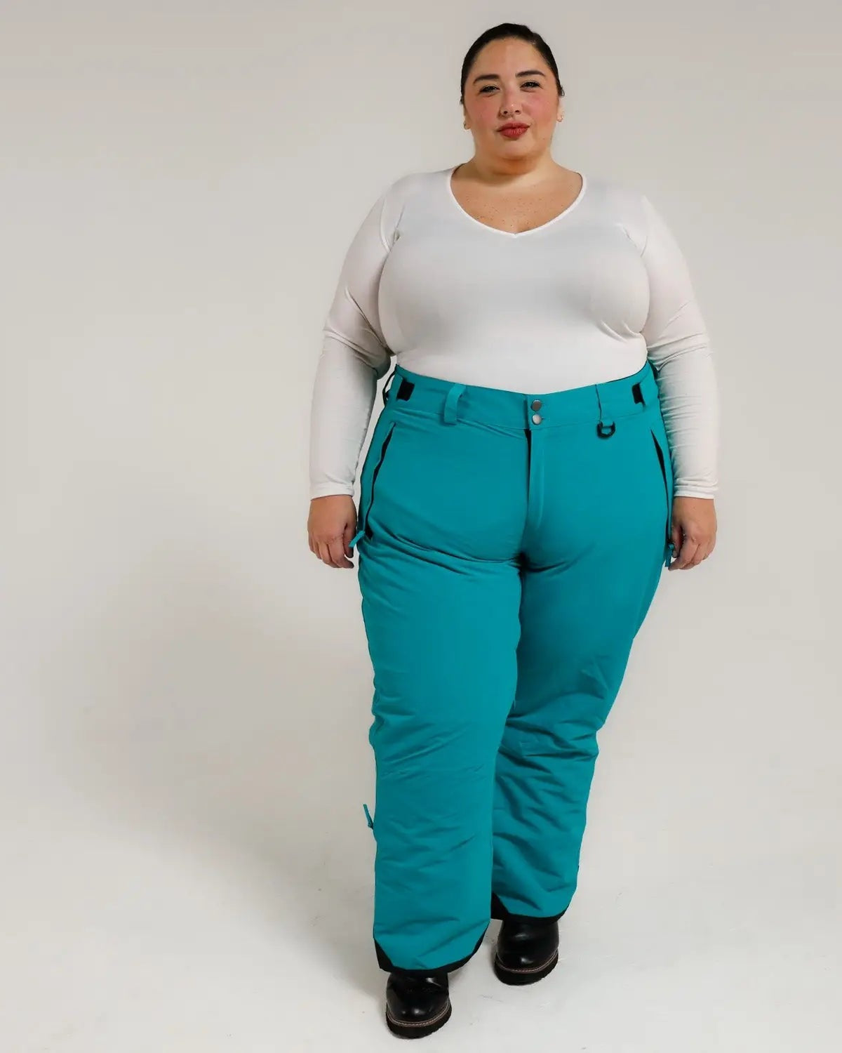 Woman wearing teal Snow Country insulated ski pants for plus size winter outdoor activity