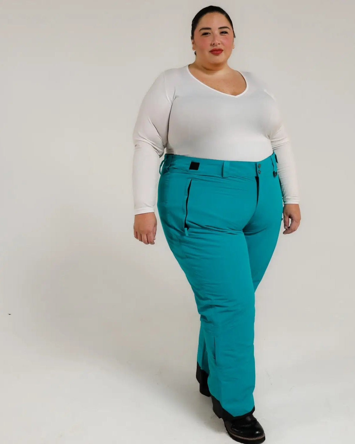 Woman wearing teal insulated ski pants from Snow Country Outerwear for women