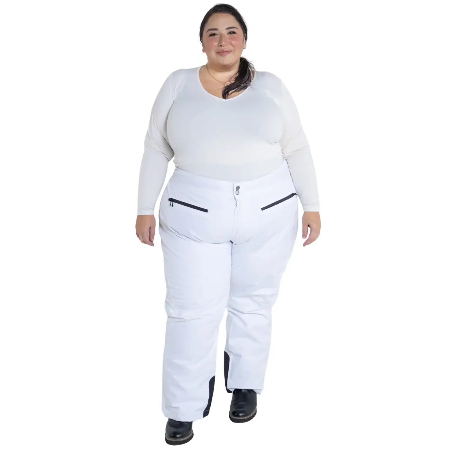 Plus-size woman in white insulated ski pants and long-sleeved shirt for winter skiing